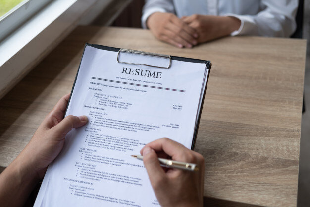 employer-interviewing-young-male-job-seeker-sitting-table-reading-his-cv-viewed-fro_55099-161